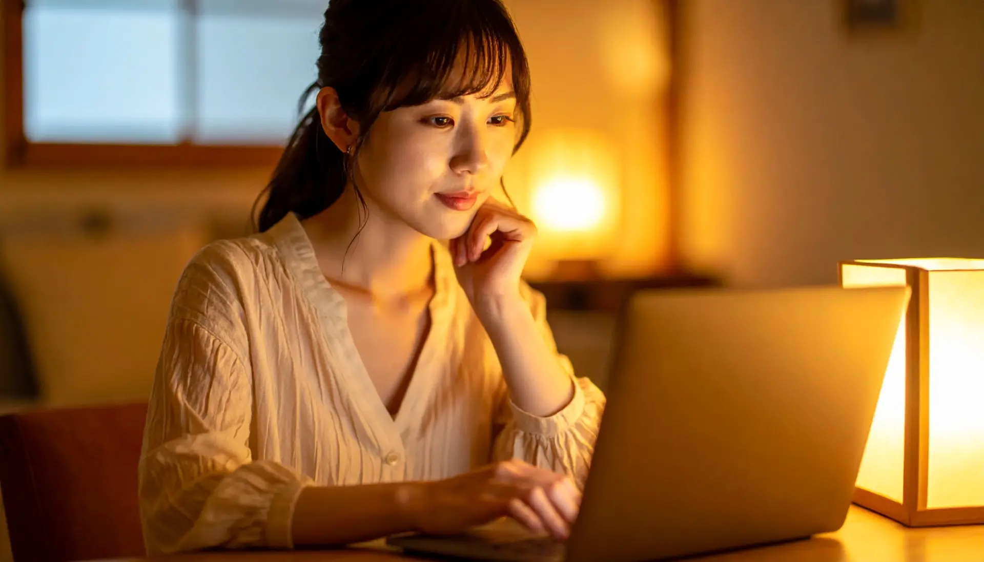 日本のカフェでノートパソコンを使い宮崎の地図を見ながら情報を調べる若い日本人女性